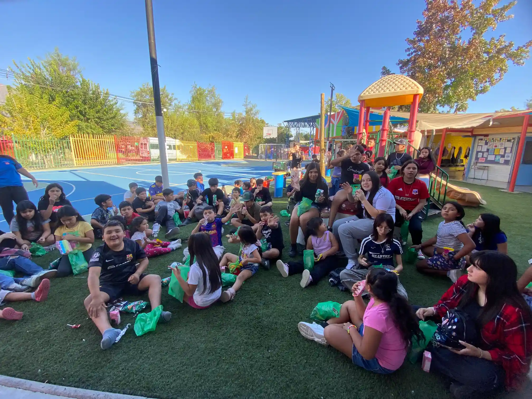 Niños, niñas y adolescentes del Patio Don Bosco recibiendo regalos